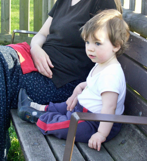 Mother sits on bench with toddler