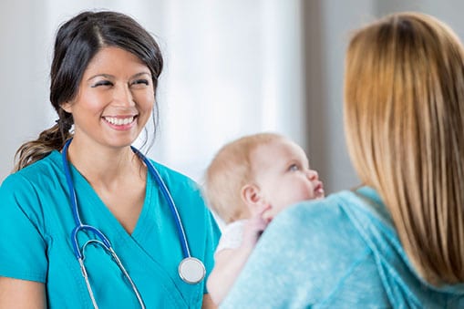 Nurse talks to new mother during an appointment.