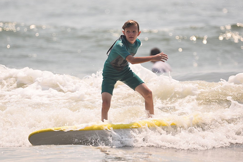 Jeffrey at 10 surfing on a surf board in the ocean